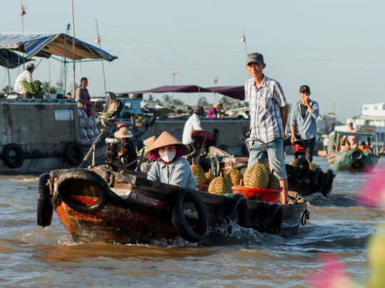 Capturing a moment of daily life on the river, showing locals going about their routines at the floating market.
