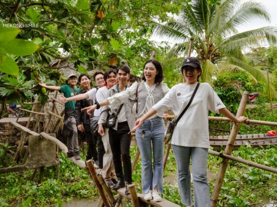 A person enjoying the experience of crossing a monkey bridge, capturing the authentic and adventurous spirit of the tour of can tho city