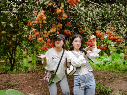 A traveler showing their excitement while visiting a lush, fruit-filled garden on Son Islet.