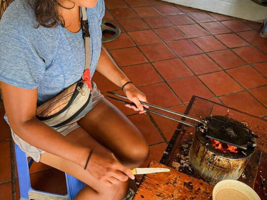 A person trying their hand at pouring batter to make a traditional Vietnamese cake or pancake.