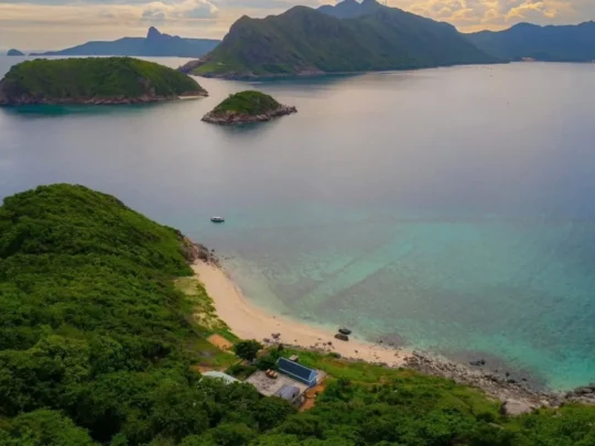 Aerial view of Hon Tai Island with green hills and turquoise sea in Con Dao