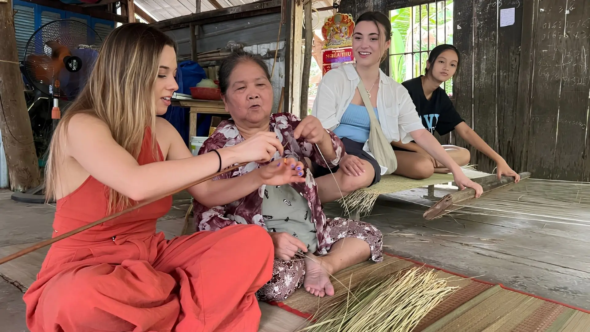 Tourists chatting with a local weaving family at An Hiep Mat Weaving Village
