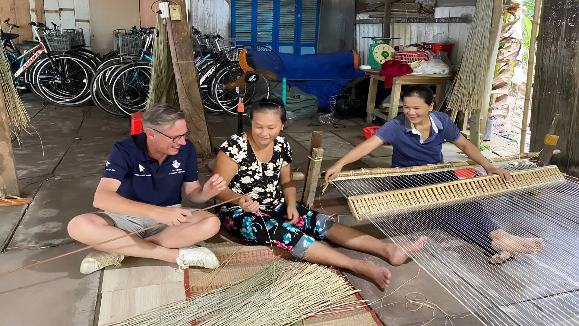 An Hiep Mat Weaving Village: A Hidden Craft Village in Ben Tre 158 A guide and tourists sitting with a weaver in An Hiep Mat Weaving Village