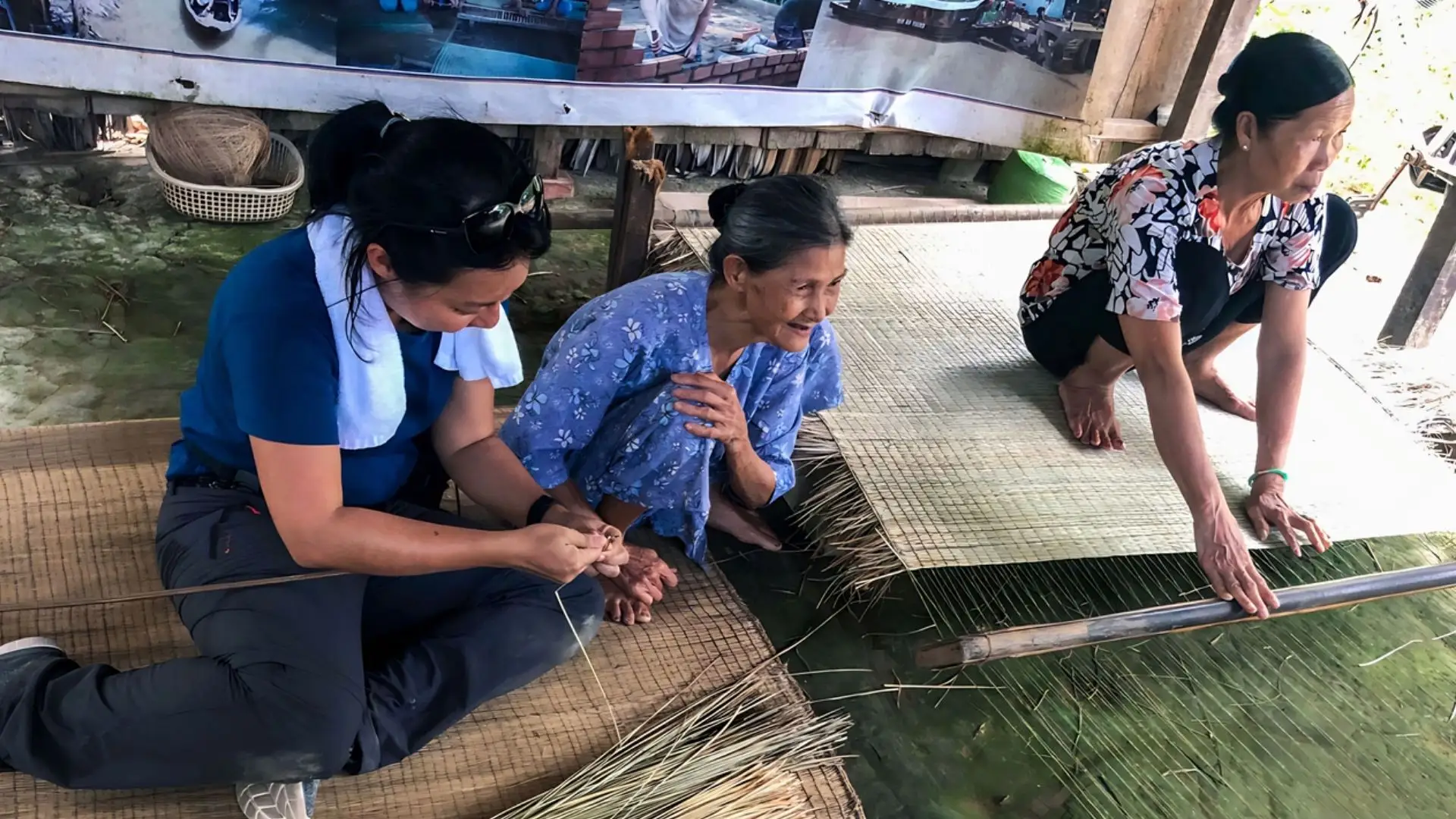 Close-up of a local woman operating a traditional loom at An Hiep Mat Weaving Village