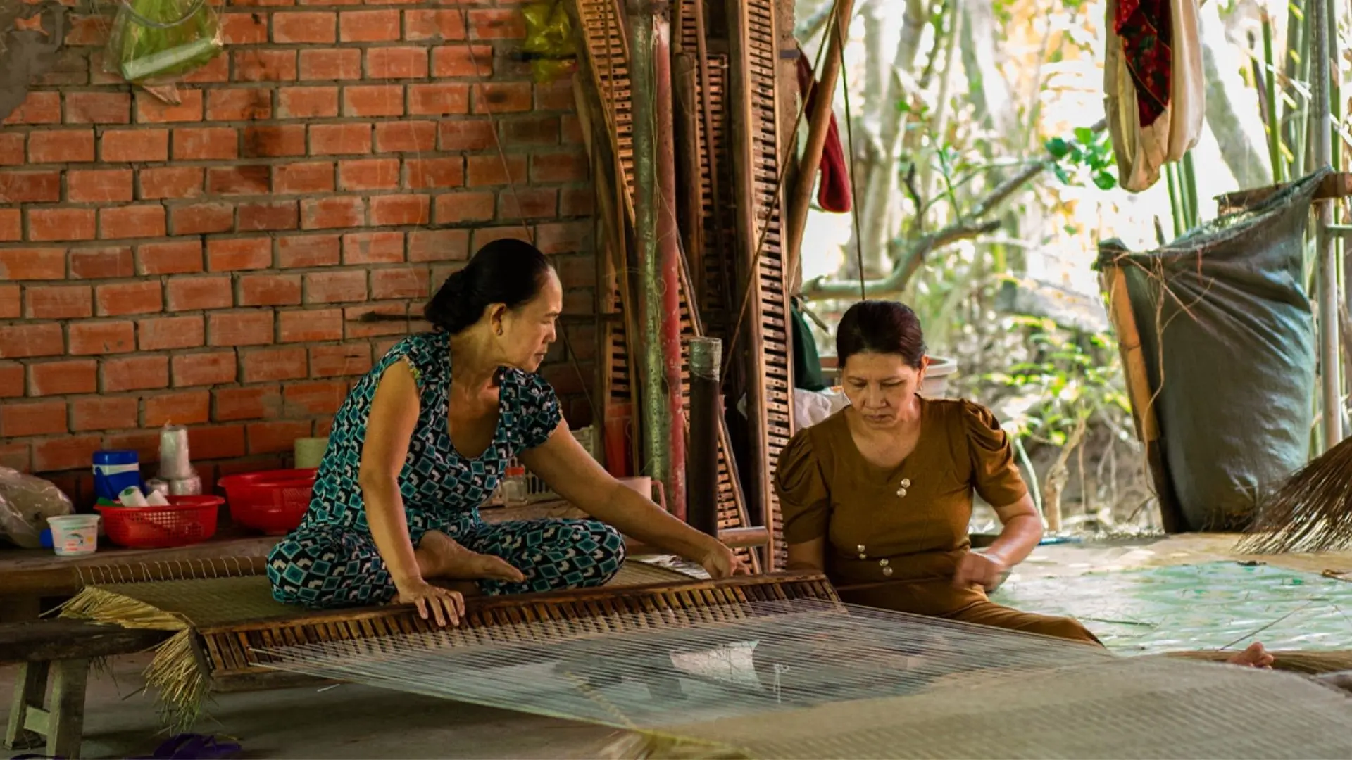 An Hiep Mat Weaving Village: A Hidden Craft Village in Ben Tre 153 Two local women working together on a large mat at An Hiep Mat Weaving Village