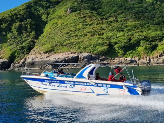 Boat cruising along Ba Island during an afternoon snorkeling and sunset route