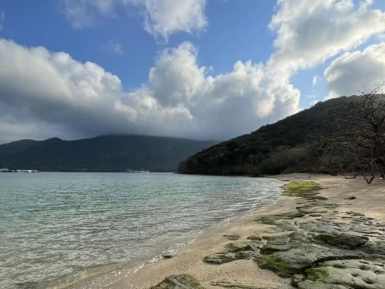 Rocky shoreline and calm coastal water around Ba Island in Con Dao