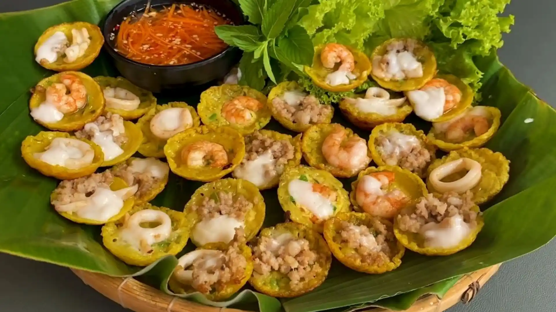 What to Eat in Vietnam: 30 Must-Try Dishes 97 Mini bánh khọt savory pancakes topped with shrimp on a banana leaf
