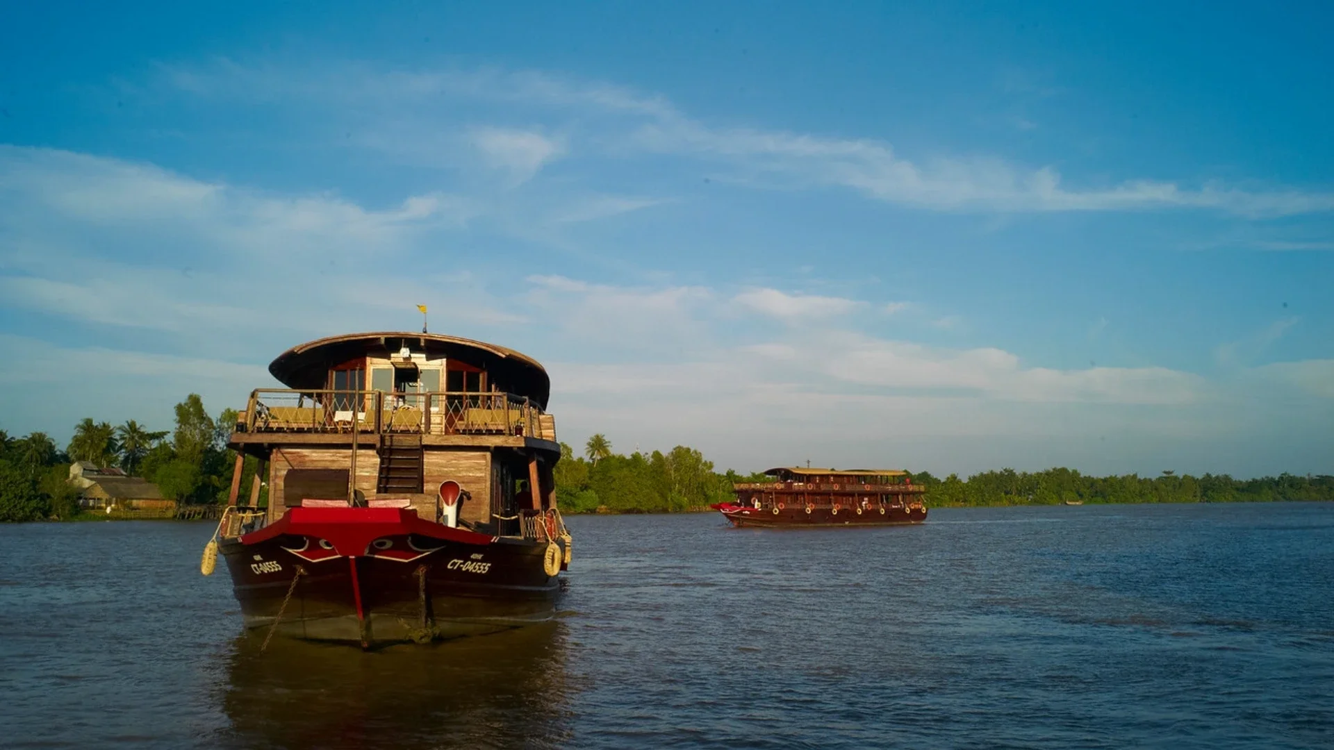 Bassac Cruise Mekong Delta boat sailing along peaceful river landscape