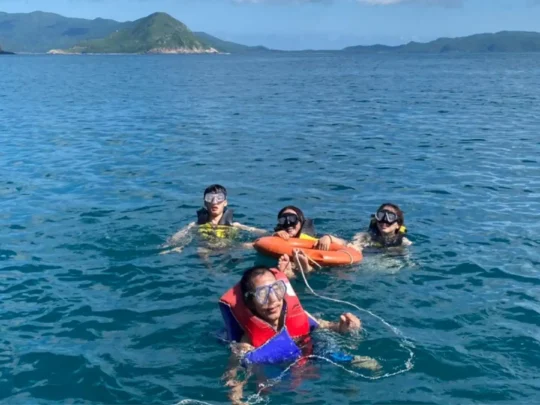 Travelers snorkeling in clear water during Bay Canh Island Tour