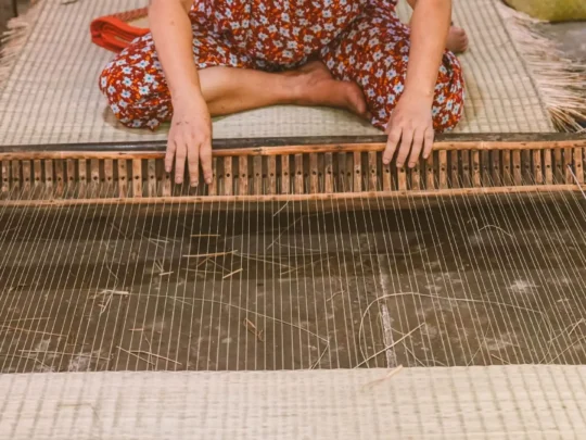 A workshop in a traditional mat weaving village in Ben Tre, with colorful sedge threads and looms