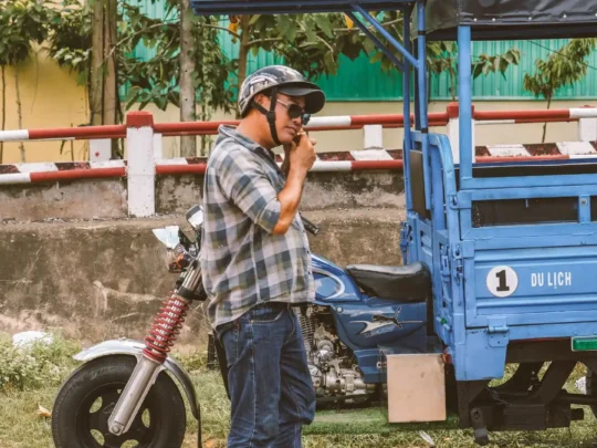 Happy tourists enjoying a fun ride on the back of a toktok through the green countryside of Ben Tre