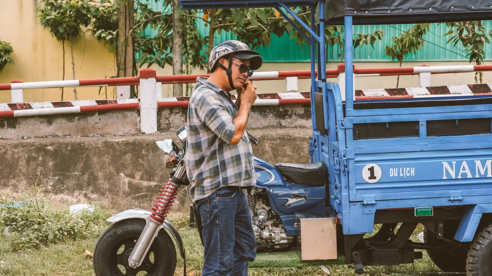 Happy tourists enjoying a fun ride on the back of a toktok through the green countryside of Ben Tre
