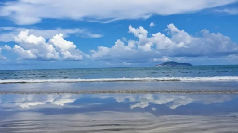 Blue sky and reflective shoreline at Vong Beach on the Bamboo Lagoon Con Dao tour