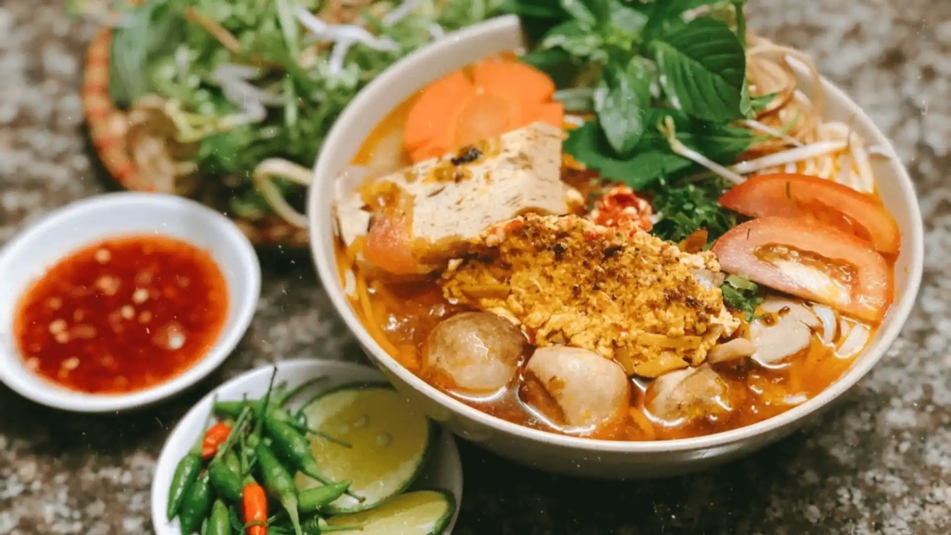 What to Eat in Vietnam: 30 Must-Try Dishes 83 Bowl of bún riêu noodle soup with tomato broth and fresh herbs