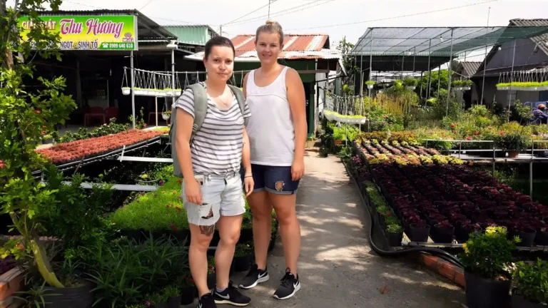 International tourists posing at a local house in Cai Mon Orchard Village