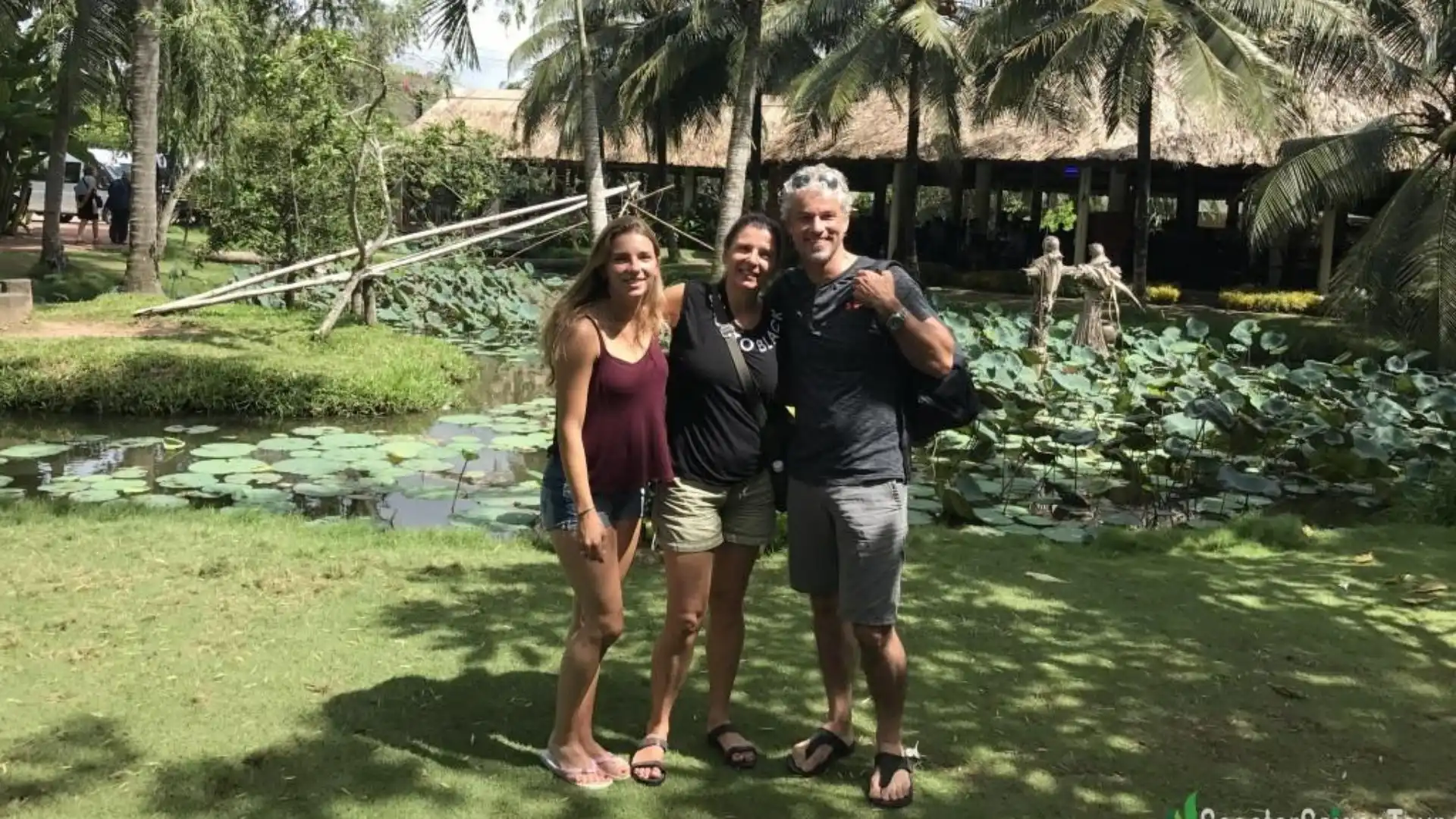 A group of travelers exploring the gardens of Cai Mon Orchard Village