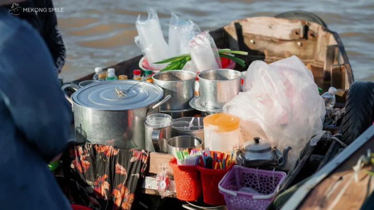A small, functional kitchen on a boat, demonstrating how vendors cook and serve food directly on the water at Cai Rang floating market tour