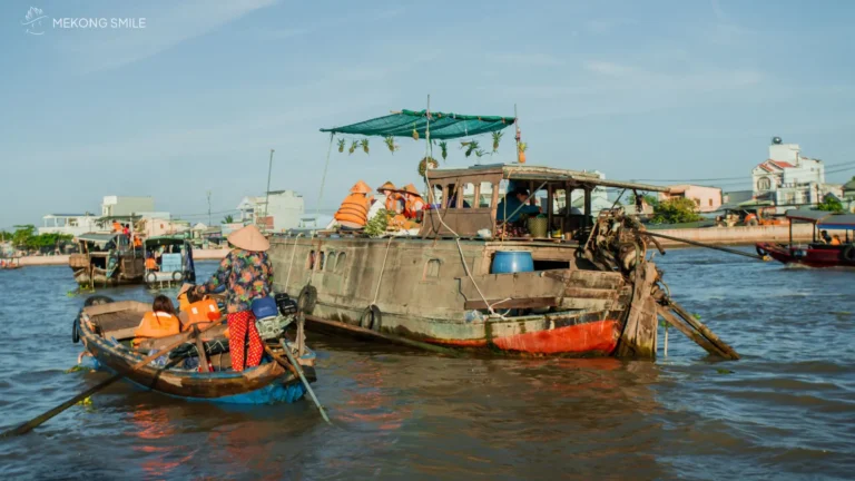 A bustling scene of boats and vendors trading goods at the Cai Rang Floating Market, Cai Rang floating market tour