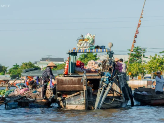 A bustling scene of boats and vendors trading goods at the Cai Rang Floating Market, showcasing the unique river life of the Mekong Delta.