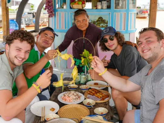A group of travelers enjoying a meal together, sharing the food they prepared in the cooking class.