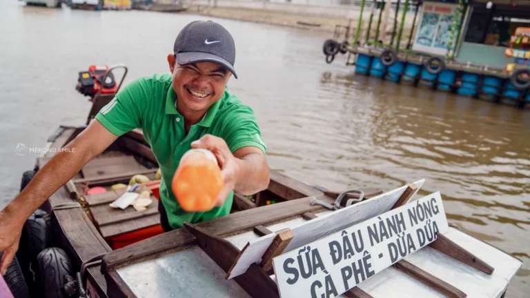 A close-up shot of a friendly local's face, capturing the warmth and hospitality of the people in the Mekong Delta.