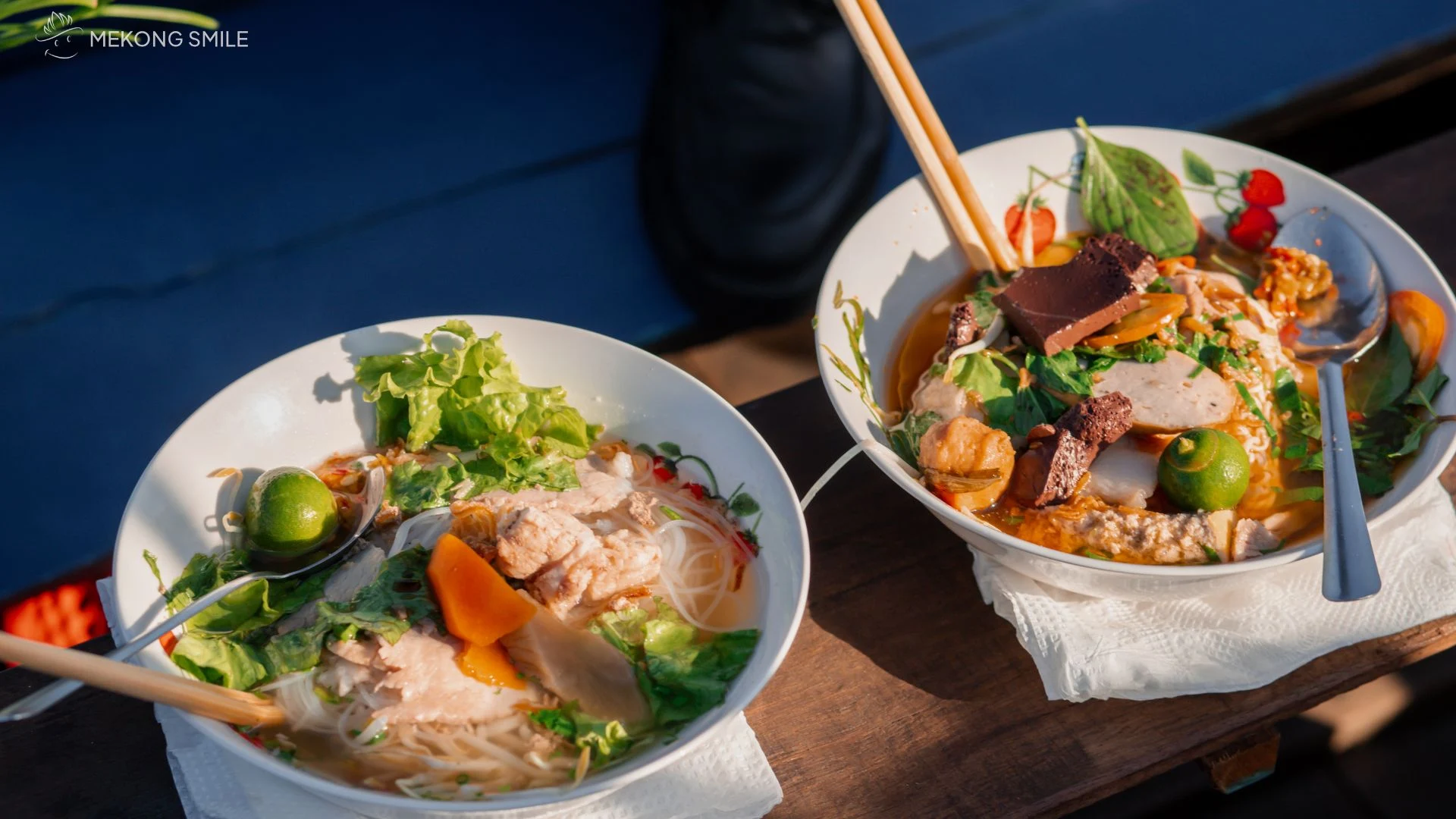 A close-up shot of a steaming bowl of Hu Tieu noodle soup, Cai Rang floating market tour