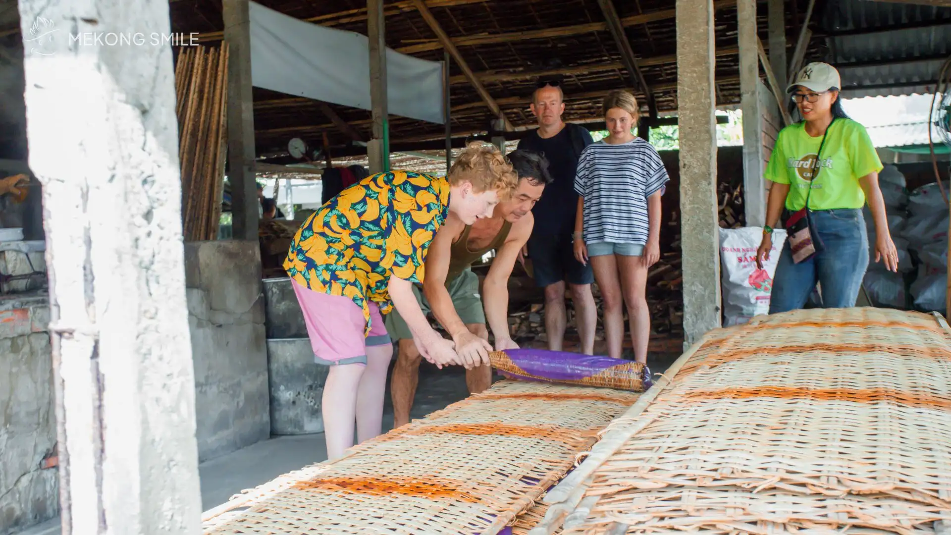 A person carefully spreading rice paper batter into a thin layer on a steaming cloth, in Cai Rang floating market tour