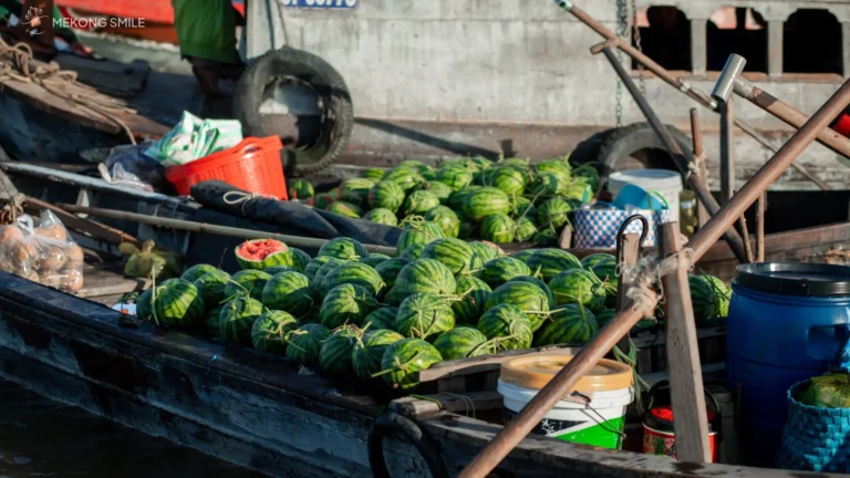 A traditional wooden boat laden with fresh agricultural produce at Cai Rang floating market