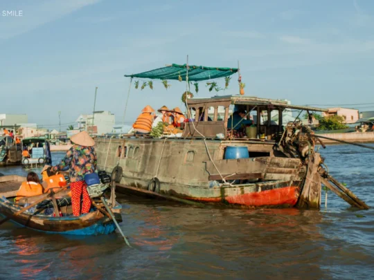 A bustling scene of boats and vendors trading goods at the Cai Rang Floating Market, showcasing the unique trading culture of the Mekong Delta.