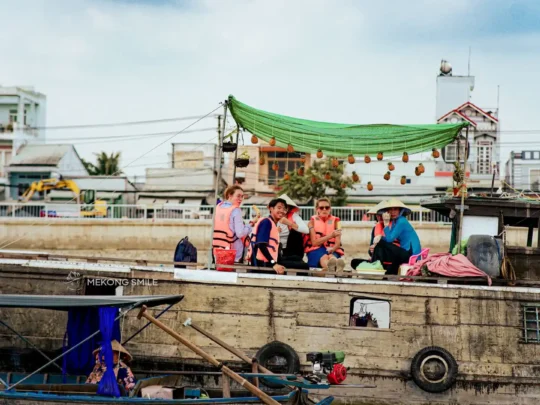 A person enjoying fresh, juicy pineapple served directly from a vendor's boat at the Cai Rang Floating Market.