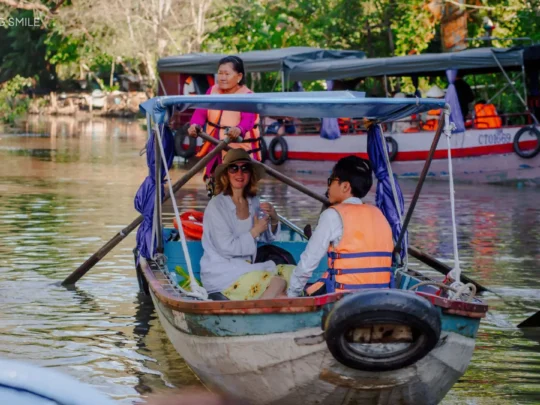 Guests boarding a traditional wooden boat for the Me Kong Smile small canal tour in Can Tho, Mekong Delta