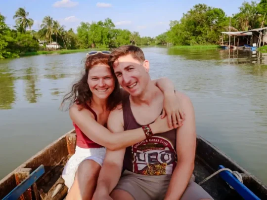 A tourist taking an iconic photo from a sampan boat on the Me Kong Smile in a Can Tho small canal tour