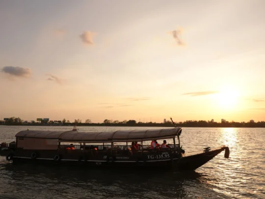 Cruise boat sailing under the golden sunset on the Hau River – Can Tho Sunset Tour with Mekong Smile