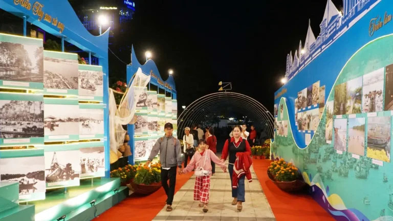 Visitors walking through a Can Tho tourism photo exhibition