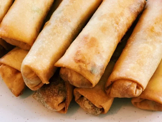 A platter of golden-brown Crispy Fried Spring Rolls (Chả Giò), a savory and popular vegetarian dish
