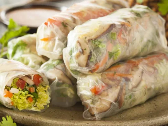A close-up shot of a Fresh Spring Roll, showing the colorful fresh vegetables and herbs rolled inside