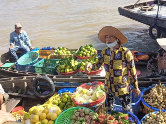 Fruit vendors selling produce from boats at Cai Rang Floating Market