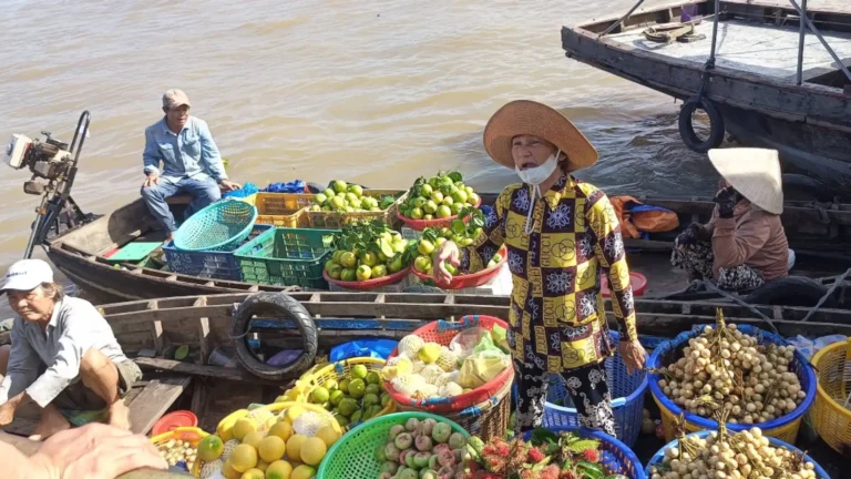 Fruit vendors selling produce from boats at Cai Rang Floating Market