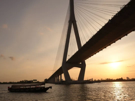 Cruise reflecting golden sunset light on return to shore – Mekong Smile Can Tho Sunset Tour