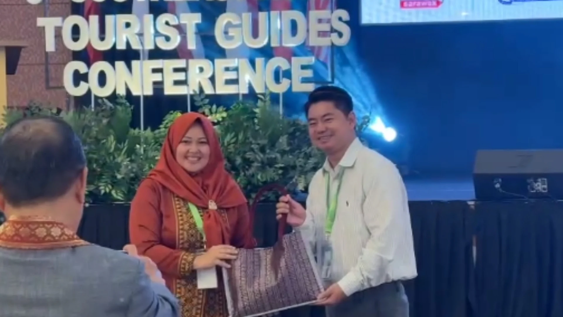 Mekong Smile Joins the 3rd Southeast Asian Tourist Guides Conference 2026 13 Ngô Minh Đức Uy (Jimmy) and a woman holding a traditional woven bag at the Southeast Asian Tourist Guides Conference 2026.