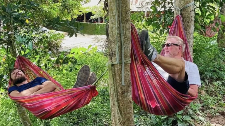 Tourist relaxing in a rope hammock under the trees in An Binh Islet tour