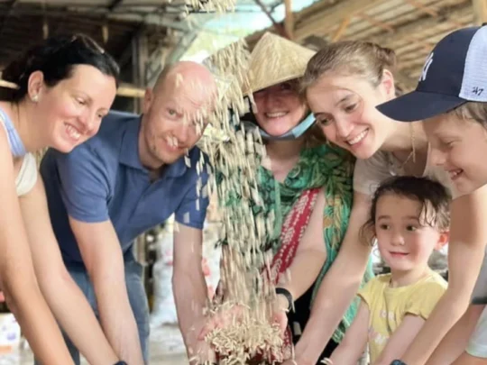 Local worker demonstrating the process of making crispy puffed rice in an binh islet tour