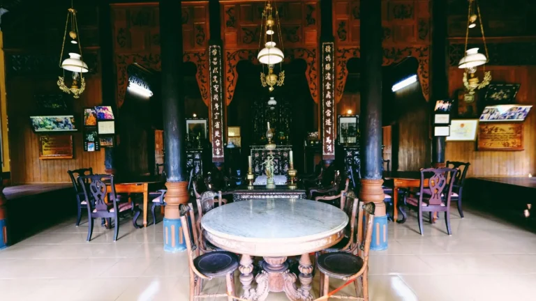 The central living room of Ba Duc Ancient House featuring antique wooden tables and traditional Vietnamese décor