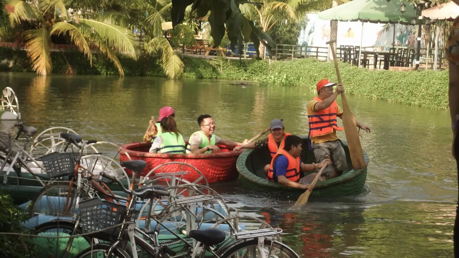Visitors taking a boat ride through canals at Bao Gia Trang Vien Ecological Village