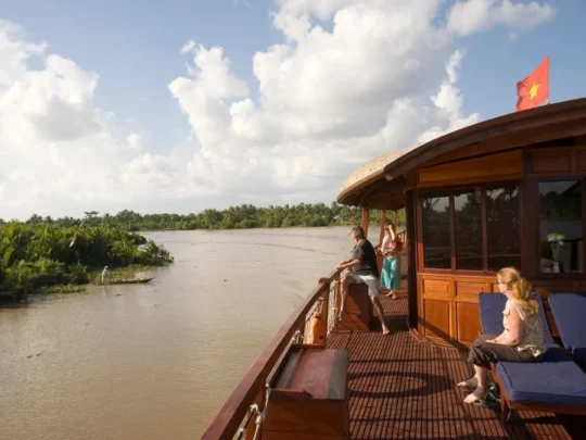 Mekong Smile Bassac Cruise Cai Be Can Tho guests relaxing on deck during river journey