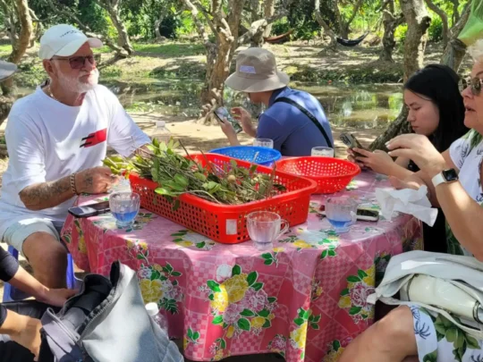 Mekong Smile Bassac Cruise Cai Be Can Tho guests enjoying local meal in garden