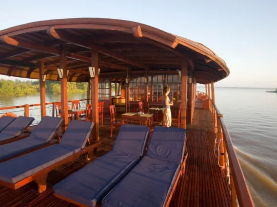 Mekong Smile Bassac Cruise Cai Be Can Tho sundeck lounge chairs overlooking Mekong River