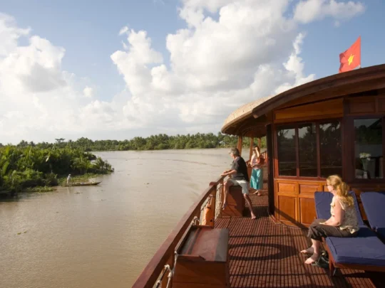 Mekong Smile Bassac Cruise Can Tho Cai Be tourists relaxing on Bassac Cruise deck along Mekong canal