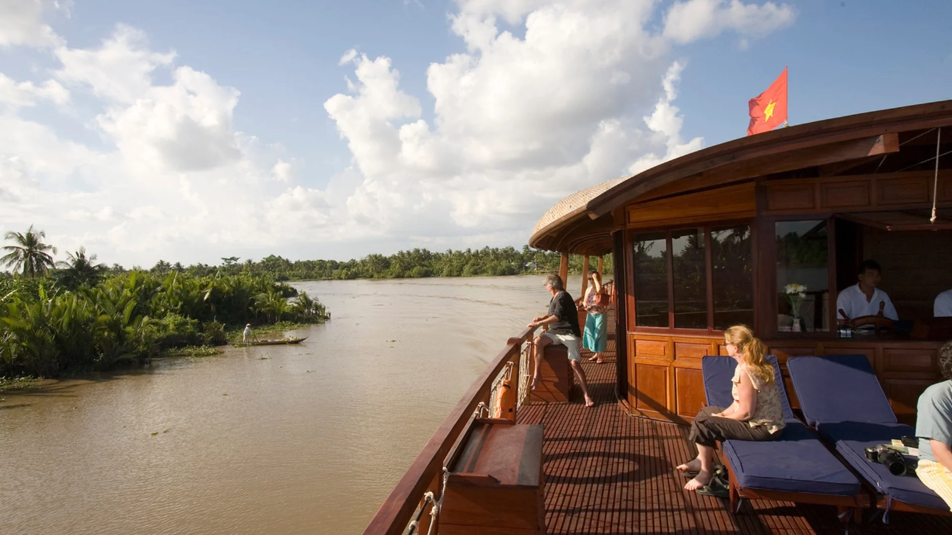 Mekong Smile Bassac Cruise Can Tho Cai Be tourists relaxing on Bassac Cruise deck along Mekong canal